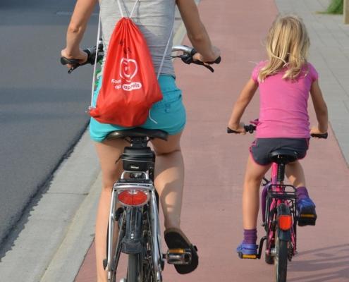 Mutter und Kind fahren Fahrrad auf Radweg